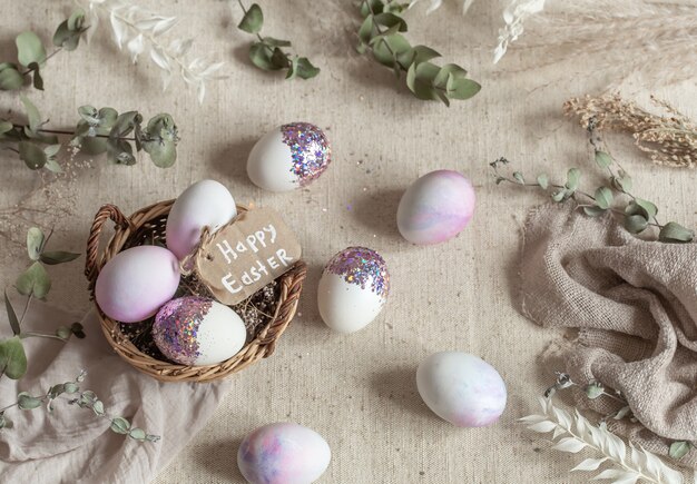 Easter still life with eggs decorated with sequins in a wicker basket. Happy easter concept