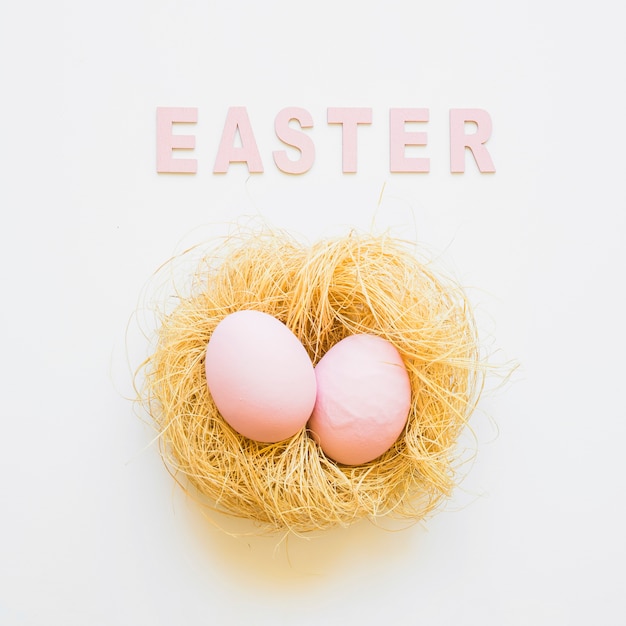 Free photo easter word and two eggs in nest