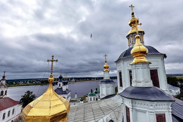 Eastern orthodox crosses on gold domes, cupolas, against blue sky with clouds. Orthodox church