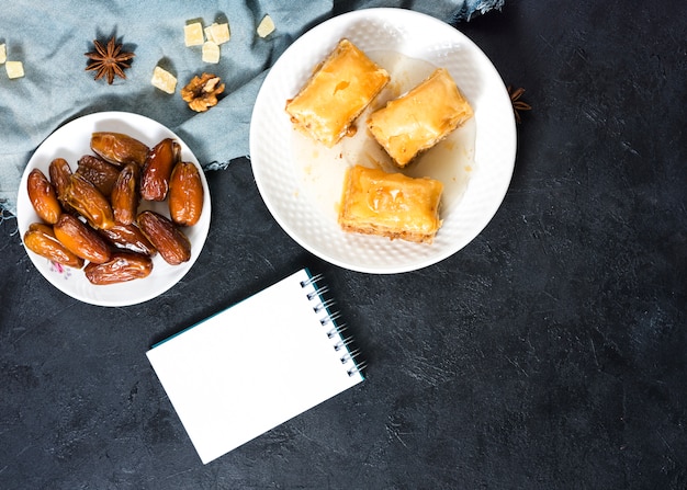 Free Photo eastern sweets with dates fruit and notepad