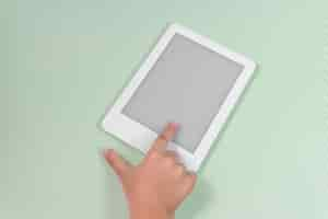 Free photo ebook reader over green background  being held by the hand of a child