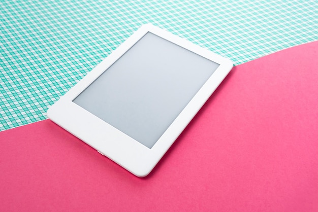 Ebook reader on the striped green background with pink