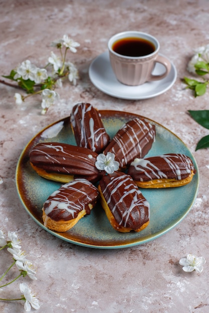 Free Photo eclairs or profiteroles with black chocolate and white chocolate with custard inside,traditional french dessert.top view.