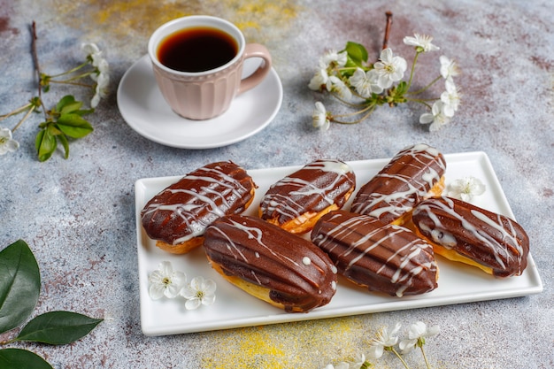 Free photo eclairs or profiteroles with black chocolate and white chocolate with custard inside,traditional french dessert.top view.