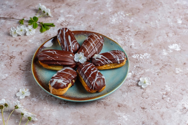 Free photo eclairs or profiteroles with black chocolate and white chocolate with custard inside,traditional french dessert.top view.