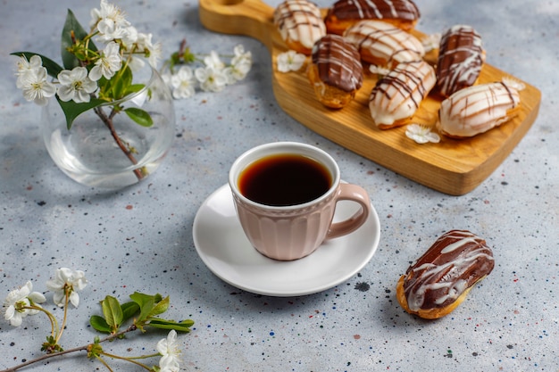 Free Photo eclairs or profiteroles with black chocolate and white chocolate with custard inside,traditional french dessert.top view.