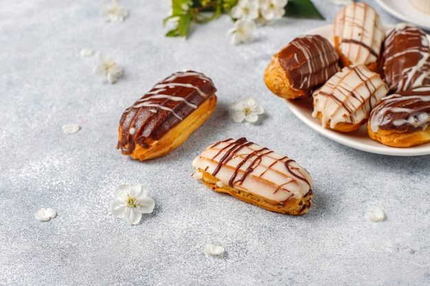 Eclairs or profiteroles with black chocolate and white chocolate with custard inside,traditional french dessert.top view.