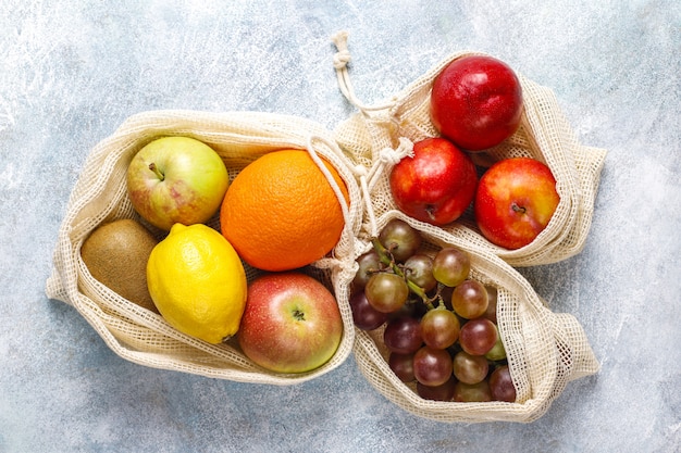 Eco-friendly simple beige cotton shopping bags for buying fruit and vegetables with summer fruits.