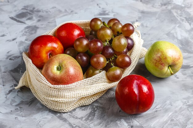 Eco-friendly simple beige cotton shopping bags for buying fruit and vegetables with summer fruits.