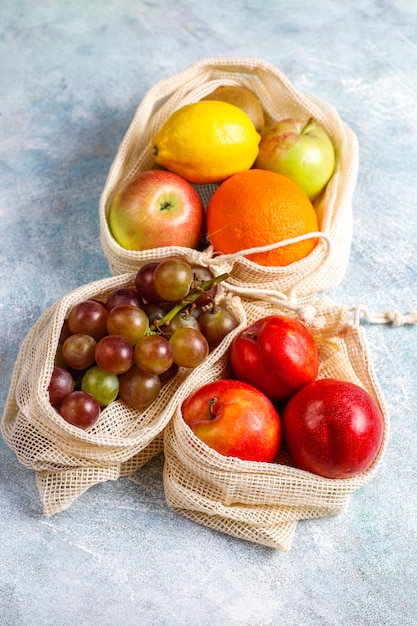 Eco-friendly simple beige cotton shopping bags for buying fruit and vegetables with summer fruits.