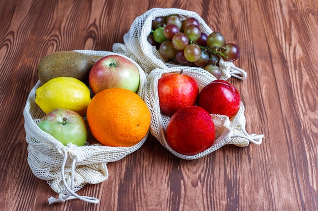 Free photo eco-friendly simple beige cotton shopping bags for buying fruit and vegetables with summer fruits.