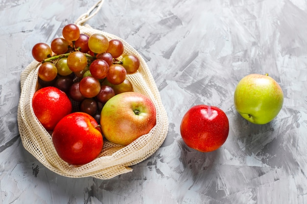 Eco-friendly simple beige cotton shopping bags for buying fruit and vegetables with summer fruits.