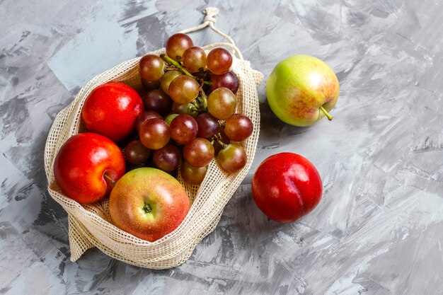 Eco-friendly simple beige cotton shopping bags for buying fruit and vegetables with summer fruits.