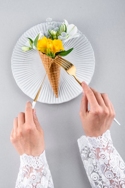 Free photo eco ice cream cone with flowers flat lay