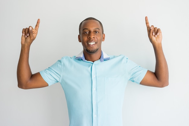 Ecstatic handsome African man showing up while recommending product. 