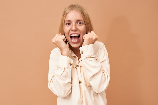 Ecstatic overjoyed lucky young winner in lottery with teeth braces cheering, celebrating success