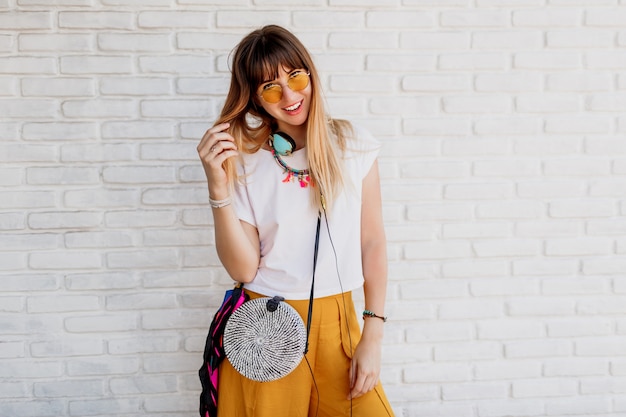 Ecstatic woman enjoying favorite music by earphones, dancing and showing pleasure.