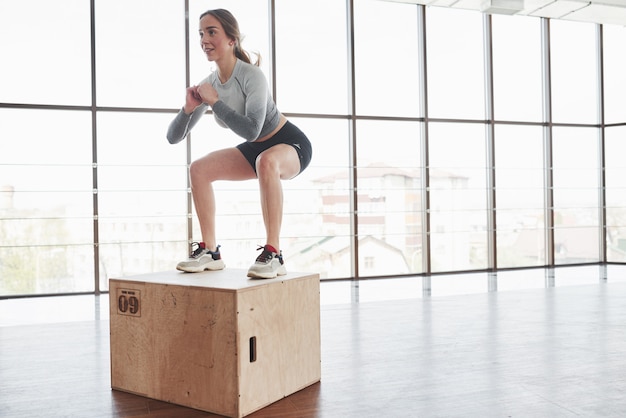 On the edge of the box. Sportive young woman have fitness day in the gym at morning time