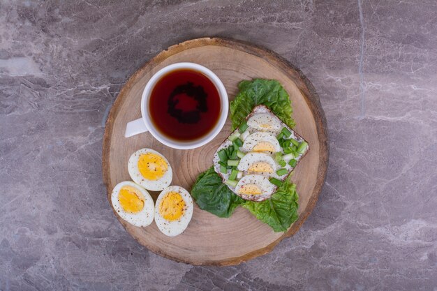 Egg sandwich with herbs and a cup of tea