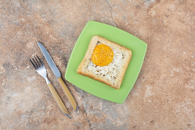 Free photo egg toast with spices on green plate with cutlery