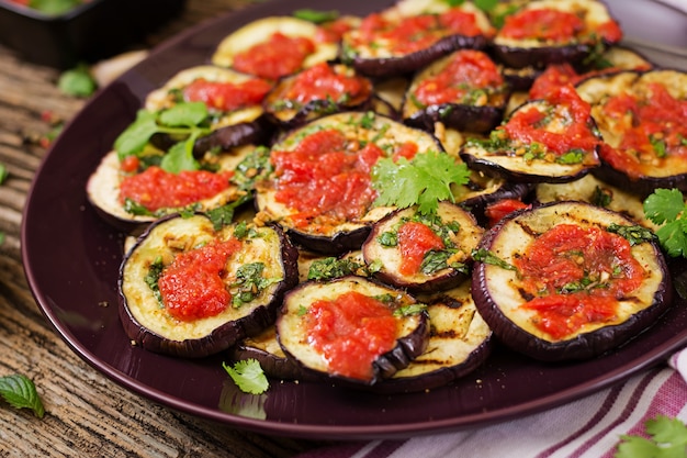 Eggplant grilled with tomato sauce, garlic, cilantro and mint. Vegan food. Grilled aubergine.