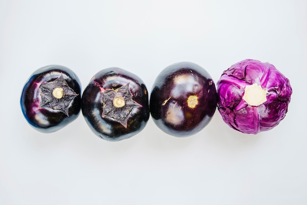 Free photo eggplant and purple cabbage arranged on white background