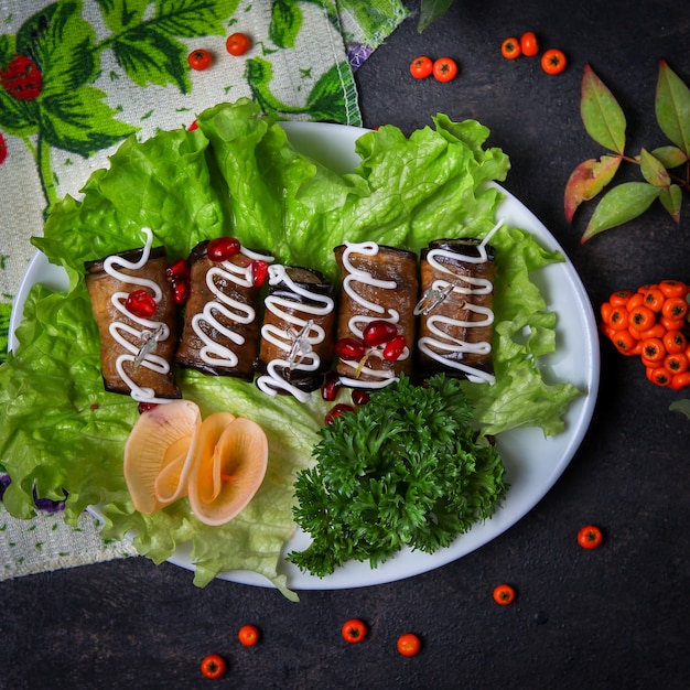 Free Photo eggplant rolls in a plate with herbs, mayonnaise, cheese, fruits, leaves