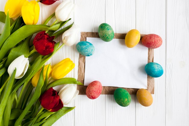 Eggs around paper near tulips