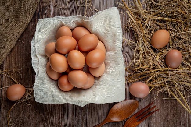 Eggs in cups on burlap with dry grass.