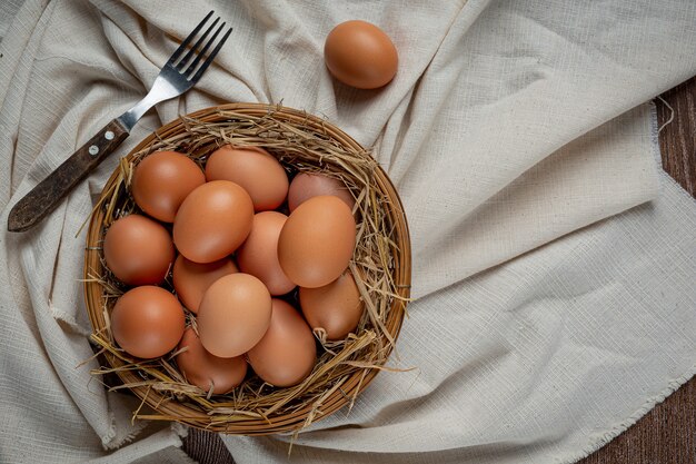 Eggs in cups on burlap with dry grass.