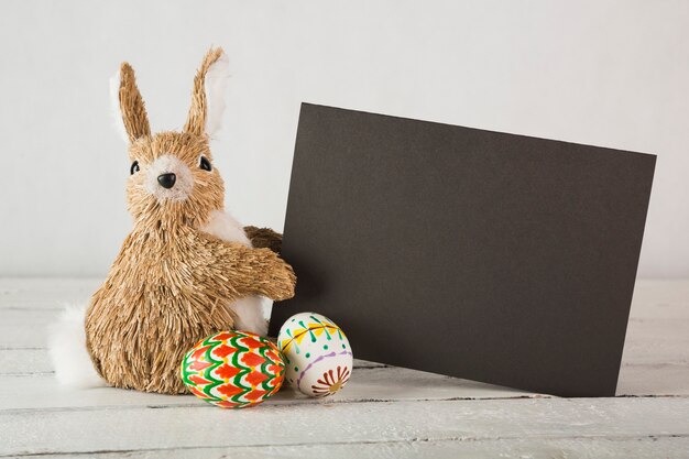 Eggs near bunny with paper