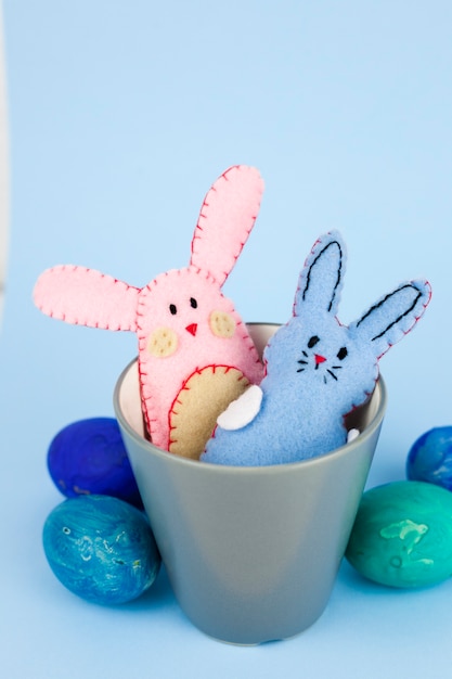 Free photo eggs near toy rabbits in cup