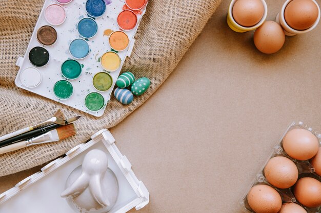 Eggs and paints on table with canvas