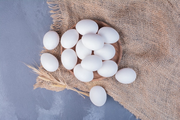 Eggs in a wooden platter on a piece of burlap