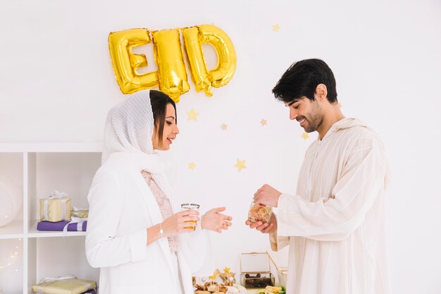 Eid al-fitr concept with couple eating cookies