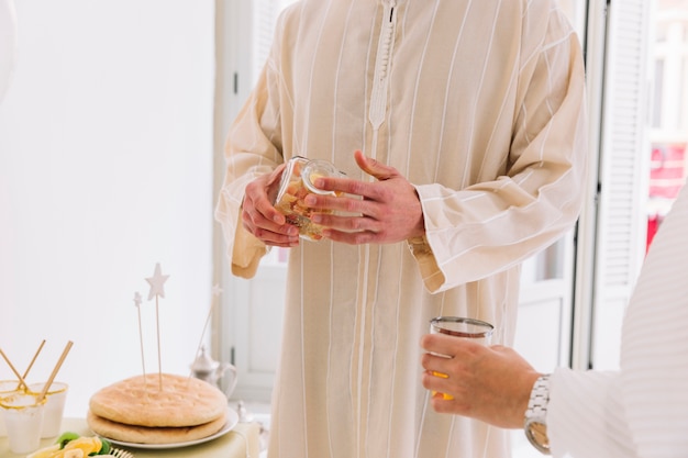 Free photo eid al-fitr concept with man holding jar of cookies