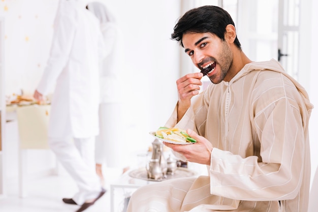 Eid al-fitr concept with man presenting arab pastry