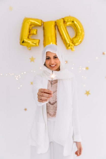 Free photo eid al-fitr concept with muslim woman holding sparkler