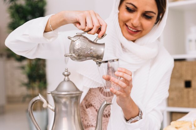 Eid al-fitr concept with woman pouring tea