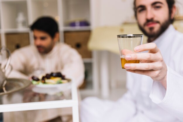 Eid concept with man showing glass of tea