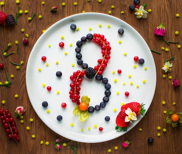 Eight shape written with black currant, cranberry and balckberry in a plate