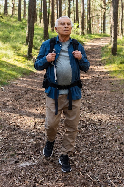 Elder man backpacking in nature