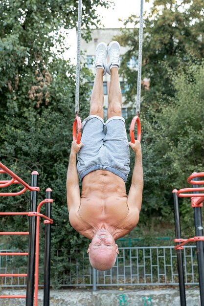 Elder man upside-down enduring full shot 