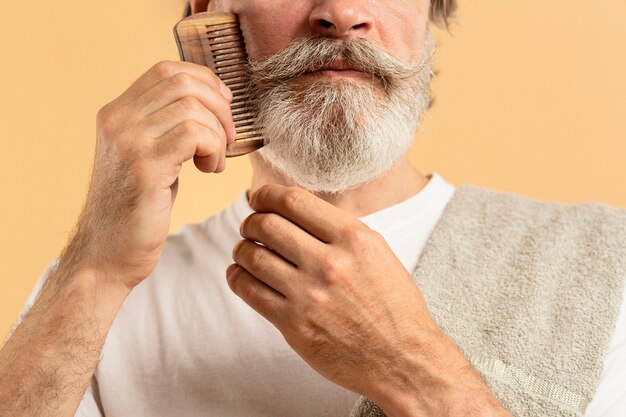 Elder man with towel combing his beard