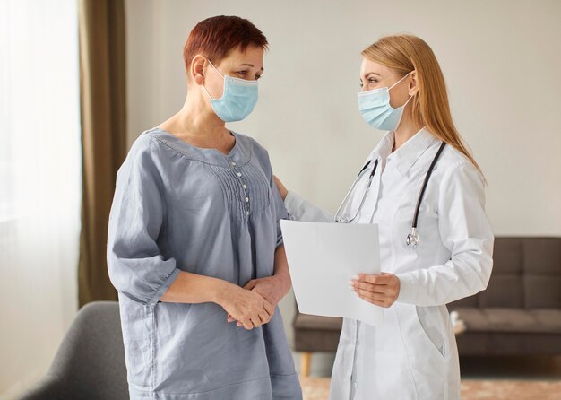 Elder patient with medical mask and covid recovery center female doctor