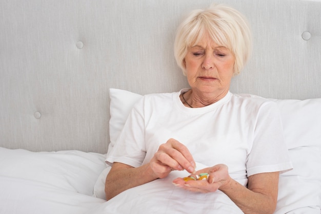 Elder woman holding pills