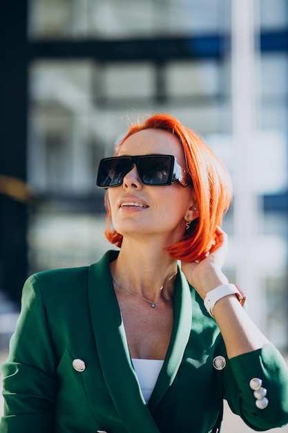 Elderly business woman in green suit outdoors