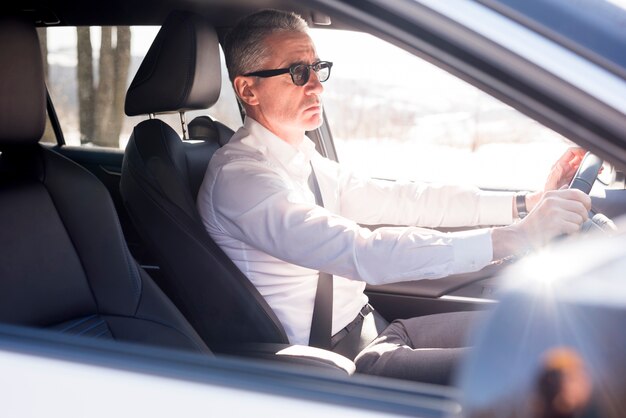 Elderly businessman driving