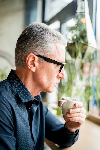 Elderly businessman having up of coffee