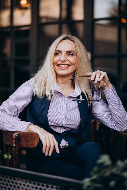 Elderly businesswoman sitting outside the cafe